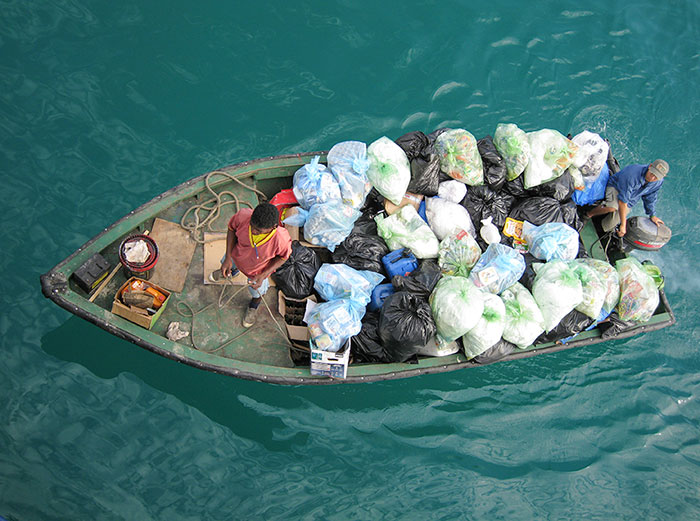 Tourist impact: A dinghy picks up trash and recycling from yachts moored in Academy Bay in Puerto Ayora, Santa Cruz Island. ©Joshua Brockman 2007. All Rights Reserved.