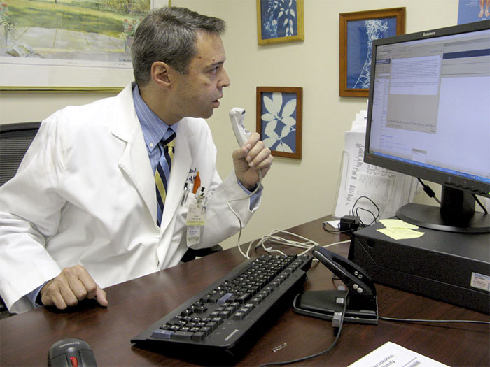 Dr. Carlo Tornatore, director of the Multiple Sclerosis Center at Georgetown University Hospital, uses a special medical version of Dragon voice recognition software to enter notes on a patient encounter.
