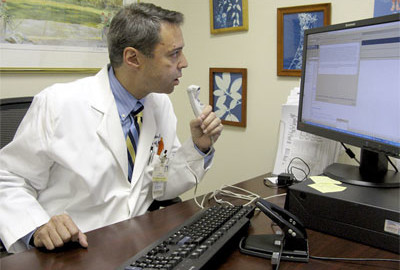 Dr. Carlo Tornatore, director of the Multiple Sclerosis Center at Georgetown University Hospital, uses a special medical version of Dragon voice recognition software to enter notes on a patient encounter.