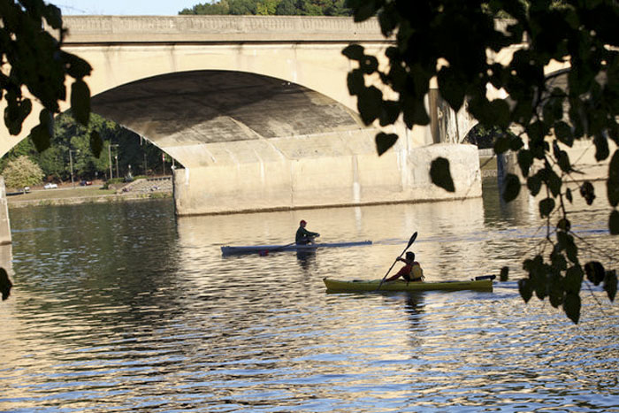 The writer kayaking near a rower on the Schuylkill in Philadelphia, by the Columbia Bridge.