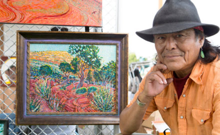 Shonto Begay, a Navajo painter, with one of his works at the Indigenous Fine Art Market. Gabriella Marks for The New York Times.